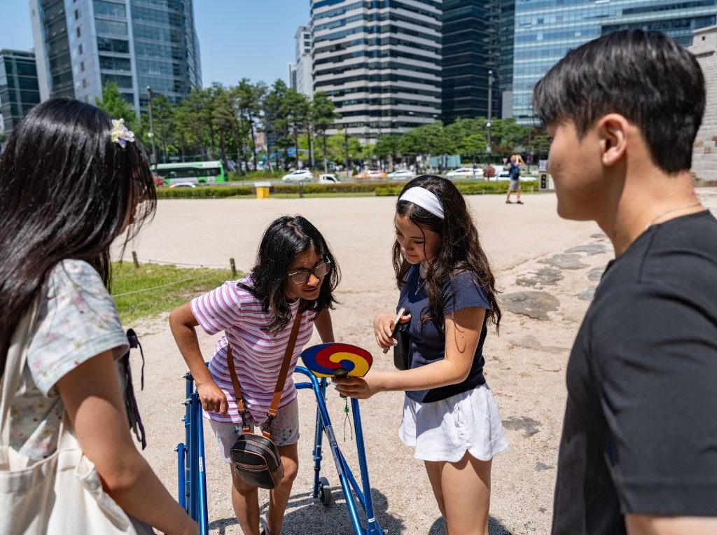 Scavenger Hunt SeoulQuest Mentor with Students Looking at Clue Candid Serious HZ